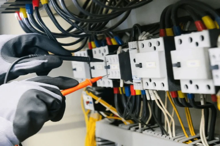 فني يفحص لوحة الكهرباء بجهاز قياس